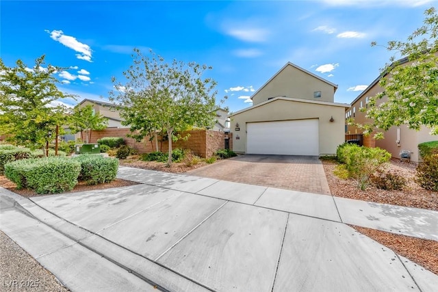 view of property hidden behind natural elements with fence, driveway, stucco siding, and a garage
