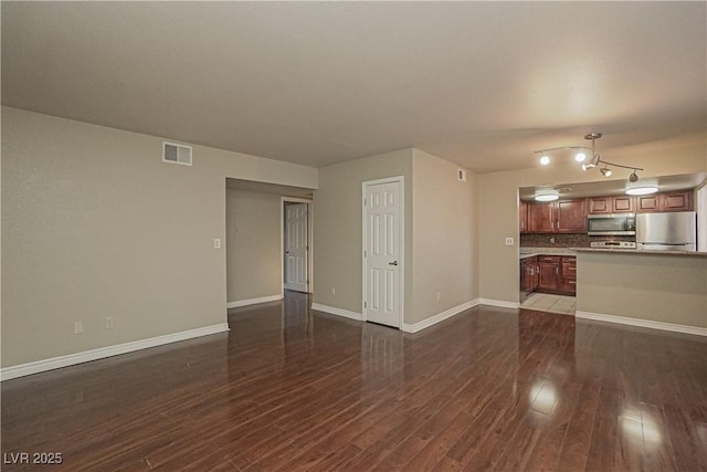 unfurnished living room with wood finished floors and baseboards