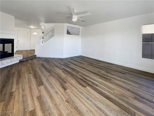 983 Plantain Lily Ave, Las Vegas, NV 89183 - unfurnished living room with ceiling fan, dark wood finished floors, baseboards, and a multi sided fireplace