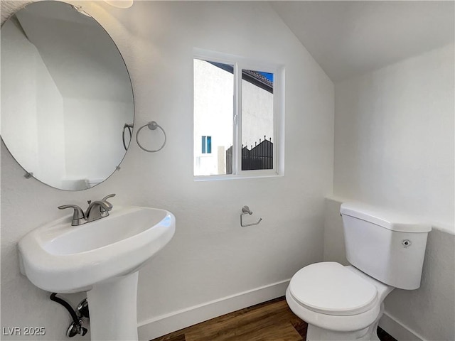983 Plantain Lily Ave, Las Vegas, NV 89183 - half bathroom featuring vaulted ceiling, toilet, baseboards, and wood finished floors