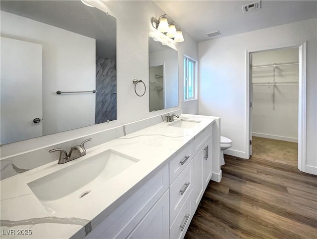 983 Plantain Lily Ave, Las Vegas, NV 89183 - full bathroom featuring wood finished floors, toilet, double vanity, and a spacious closet