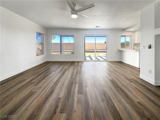 983 Plantain Lily Ave, Las Vegas, NV 89183 - unfurnished living room with ceiling fan, baseboards, and dark wood-style floors
