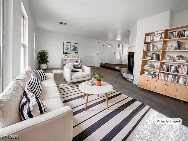 983 Plantain Lily Ave, Las Vegas, NV 89183 - living room featuring a glass covered fireplace and dark colored carpet