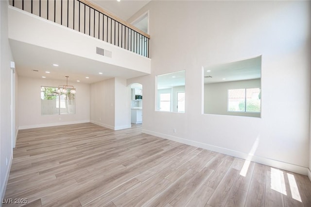 1620 Western Lily St, Las Vegas, NV 89128 - unfurnished living room with plenty of natural light, light wood finished floors, baseboards, a high ceiling, and recessed lighting
