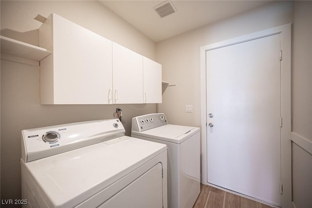 1620 Western Lily St, Las Vegas, NV 89128 - laundry room featuring washer and clothes dryer, light wood-style flooring, and cabinet space