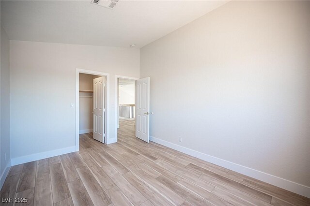1620 Western Lily St, Las Vegas, NV 89128 - unfurnished bedroom featuring lofted ceiling, light wood-style flooring, baseboards, and a closet