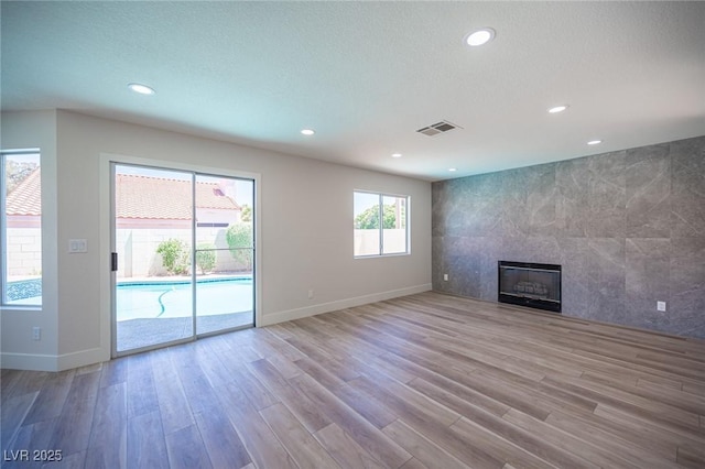 1620 Western Lily St, Las Vegas, NV 89128 - unfurnished living room featuring wood finished floors, baseboards, a tiled fireplace, and recessed lighting