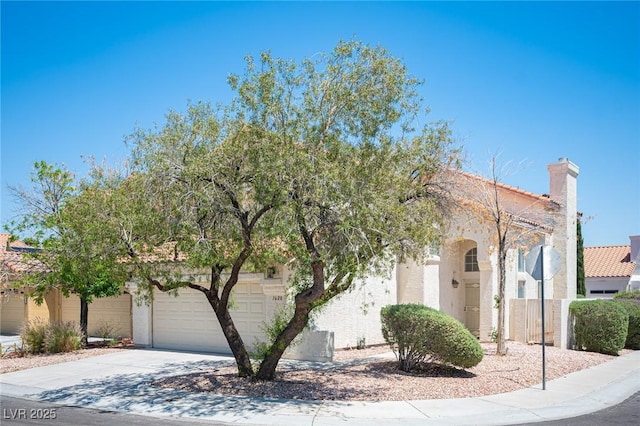 1620 Western Lily St, Las Vegas, NV 89128 - view of front of house featuring driveway, stucco siding, and a chimney