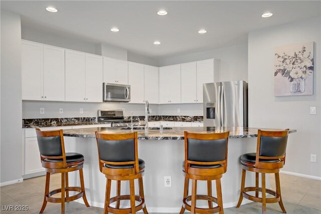 748 Dellenbaugh Ct, Las Vegas, NV 89178 - kitchen featuring appliances with stainless steel finishes, a sink, recessed lighting, dark stone counters, and white cabinets