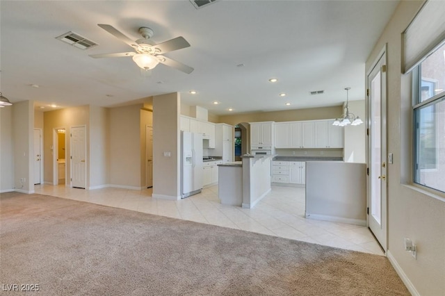 kitchen featuring light colored carpet, white cabinets, light tile patterned flooring, white appliances, and recessed lighting