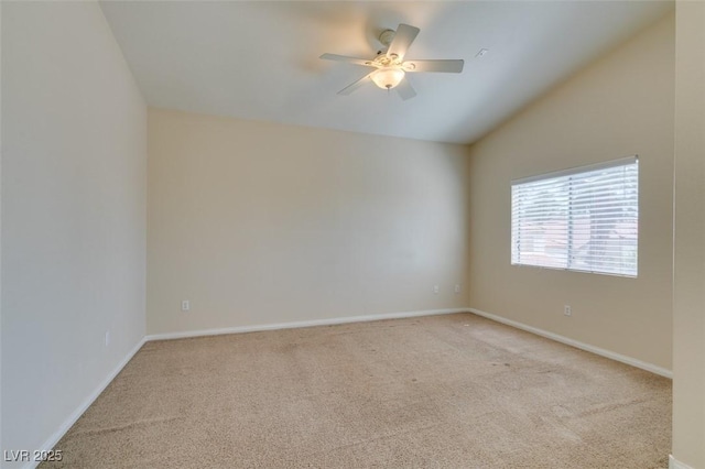 empty room with carpet flooring, a ceiling fan, baseboards, and lofted ceiling