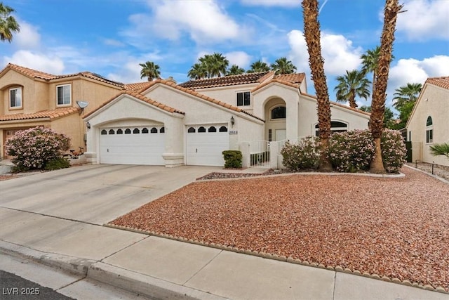 2024 Spruce Brook Dr, Henderson, NV 89074 - mediterranean / spanish house with an attached garage, driveway, stucco siding, a tile roof, and fence