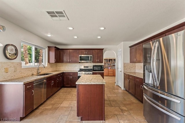 2024 Spruce Brook Dr, Henderson, NV 89074 - kitchen featuring stainless steel appliances, a sink, stone tile flooring, a center island, and tasteful backsplash