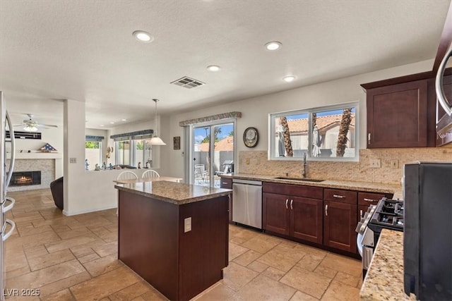 2024 Spruce Brook Dr, Henderson, NV 89074 - kitchen with a sink, stainless steel dishwasher, a ceiling fan, decorative backsplash, and stone tile flooring