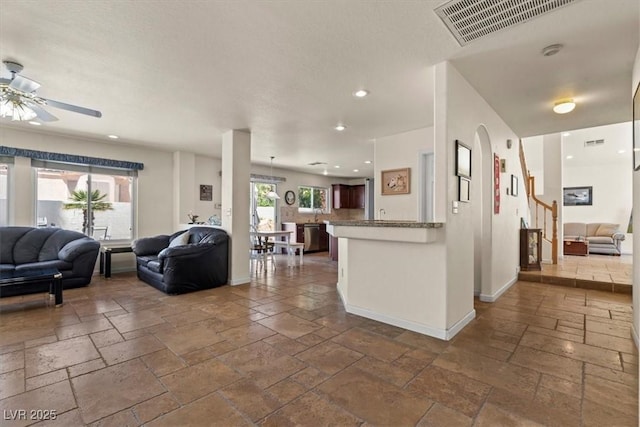 2024 Spruce Brook Dr, Henderson, NV 89074 - living room featuring stone tile floors, a ceiling fan, recessed lighting, and baseboards