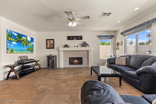 2024 Spruce Brook Dr, Henderson, NV 89074 - living room with baseboards, stone tile floors, ceiling fan, a glass covered fireplace, and recessed lighting