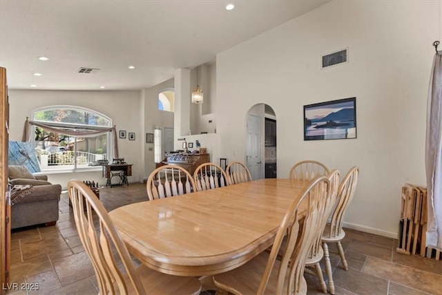 2024 Spruce Brook Dr, Henderson, NV 89074 - dining room with stone tile flooring, arched walkways, radiator, recessed lighting, and baseboards