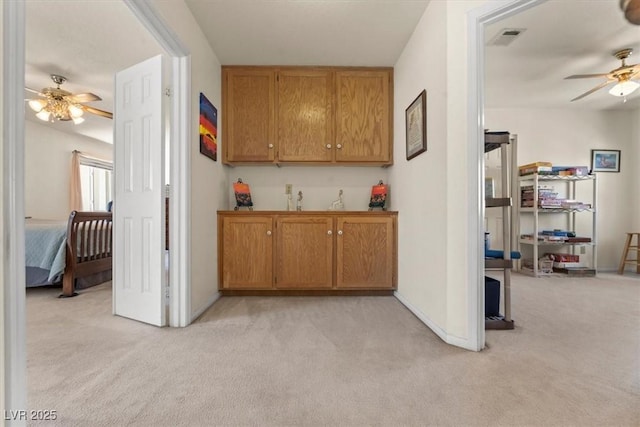 2024 Spruce Brook Dr, Henderson, NV 89074 - kitchen with ceiling fan, light colored carpet, baseboards, and brown cabinetry