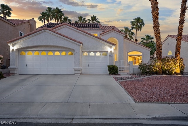 2024 Spruce Brook Dr, Henderson, NV 89074 - mediterranean / spanish home featuring a tiled roof, an attached garage, concrete driveway, and stucco siding