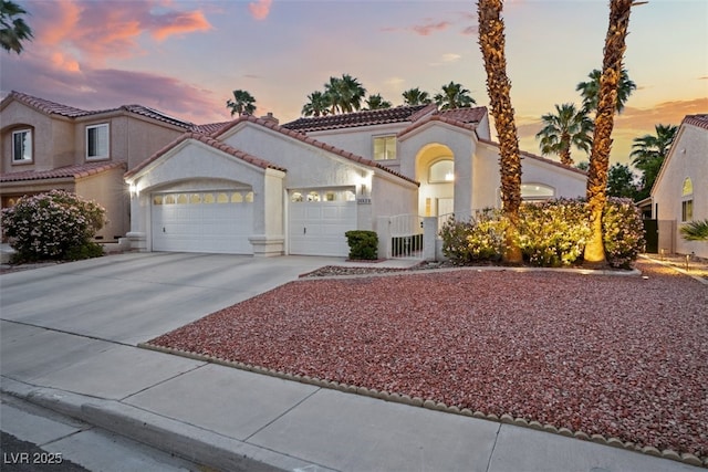 2024 Spruce Brook Dr, Henderson, NV 89074 - mediterranean / spanish-style home featuring a garage, driveway, stucco siding, a tile roof, and fence