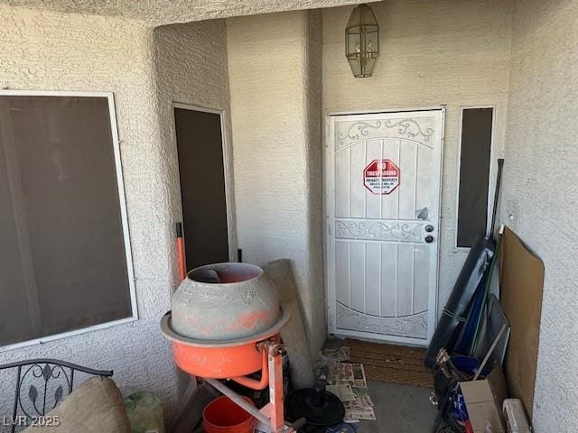doorway to property featuring stucco siding