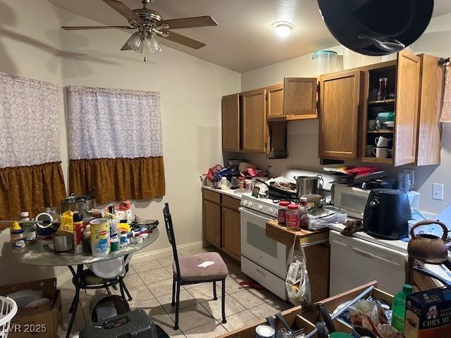 kitchen featuring a ceiling fan, lofted ceiling, white appliances, light tile patterned flooring, and brown cabinets