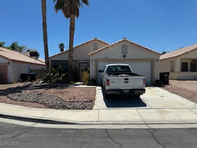 single story home with a garage, concrete driveway, and stucco siding