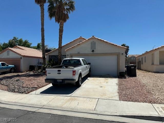single story home featuring an attached garage, driveway, and stucco siding