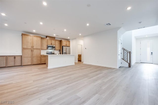 11946 Glide Reflection Ave, Las Vegas, NV 89138 - unfurnished living room featuring stairs, recessed lighting, light wood-style floors, and a sink