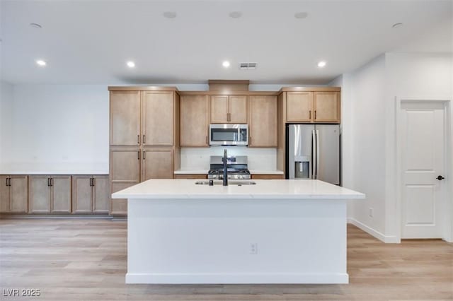 11946 Glide Reflection Ave, Las Vegas, NV 89138 - kitchen featuring appliances with stainless steel finishes, a center island with sink, light brown cabinetry, light countertops, and recessed lighting