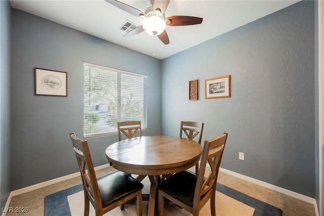 dining area with a ceiling fan and baseboards