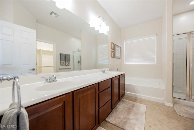 full bathroom featuring a stall shower, tile patterned flooring, a garden tub, and double vanity
