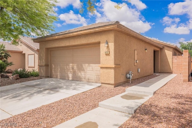 view of home's exterior with a garage, a tiled roof, stucco siding, and driveway