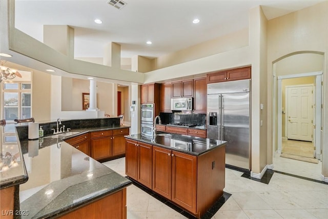 6224 Red Pine Ct, Las Vegas, NV 89130 - kitchen featuring stainless steel appliances, a sink, a spacious island, dark stone countertops, and a chandelier