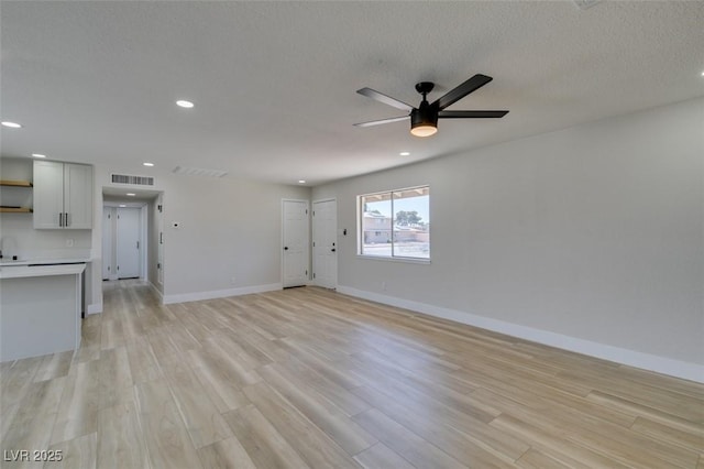 unfurnished living room with a ceiling fan, baseboards, light wood-style flooring, recessed lighting, and a sink