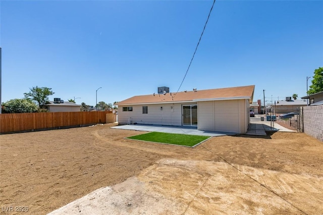 rear view of house featuring a fenced backyard and a patio