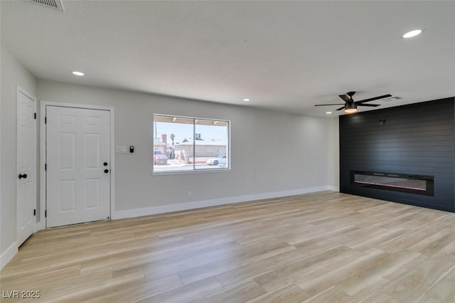 unfurnished living room with a fireplace, light wood finished floors, recessed lighting, and baseboards
