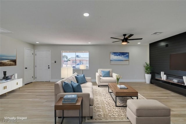 living room with light wood-type flooring, ceiling fan, baseboards, and recessed lighting