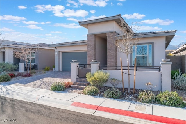 view of front of house with stucco siding, an attached garage, driveway, and fence