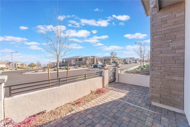 view of patio with a residential view and fence