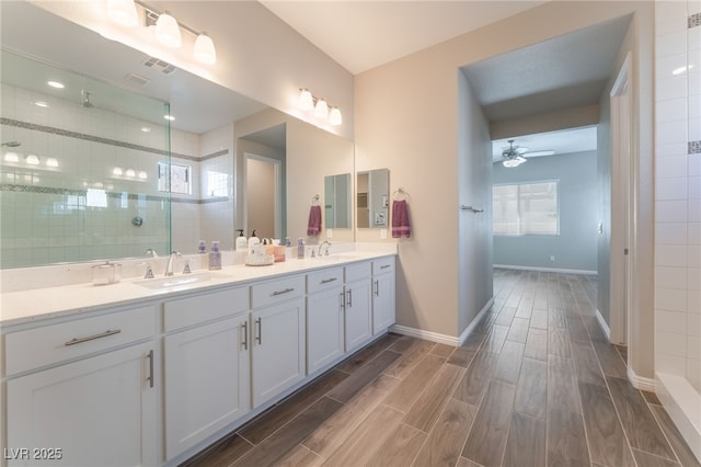 full bath with ceiling fan, tiled shower, wood tiled floors, and double vanity