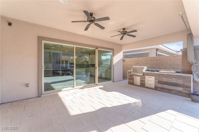 view of patio with an outdoor kitchen, area for grilling, fence, and ceiling fan