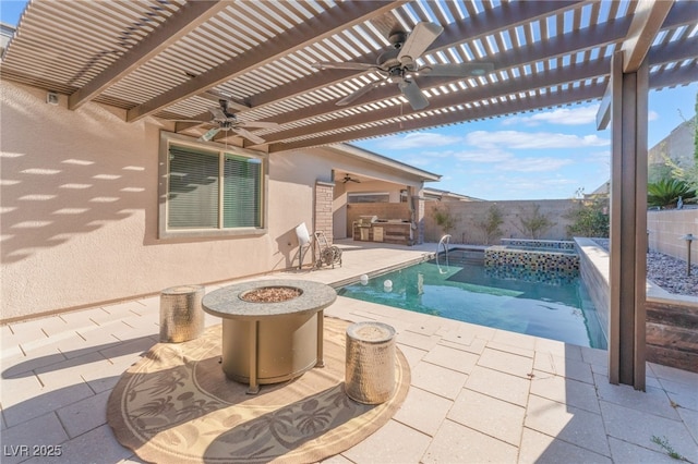 view of swimming pool featuring a ceiling fan, a fenced backyard, a fire pit, a patio, and exterior kitchen
