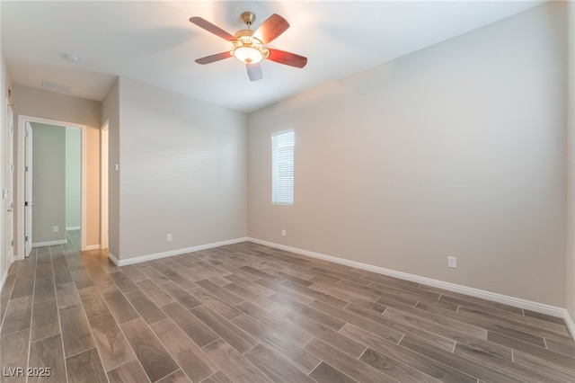 empty room with wood finished floors, baseboards, and ceiling fan
