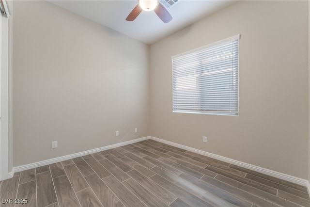 spare room featuring wood finished floors, ceiling fan, and baseboards