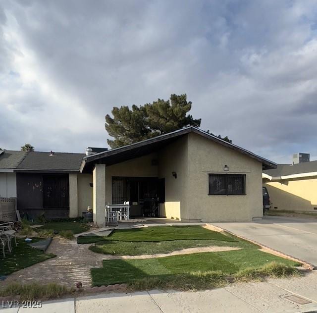 4820 Mahogany Dr, Las Vegas, NV 89110 - view of front of home with stucco siding and a front lawn