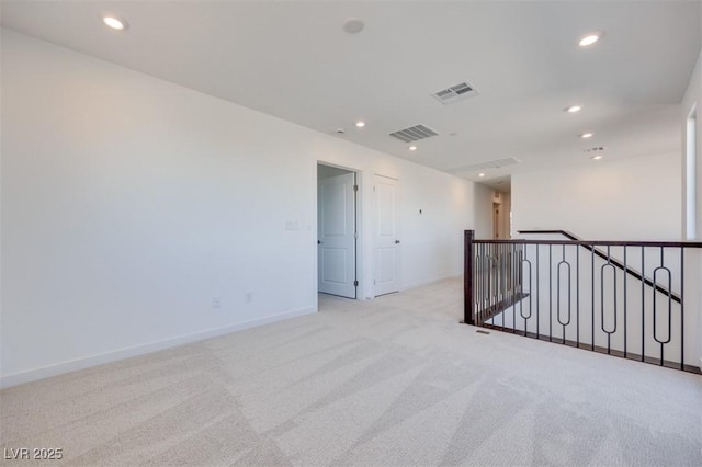unfurnished room with light carpet, recessed lighting, and baseboards