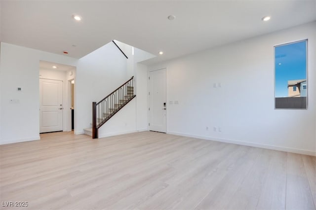 unfurnished living room with stairs, light wood-type flooring, recessed lighting, and baseboards