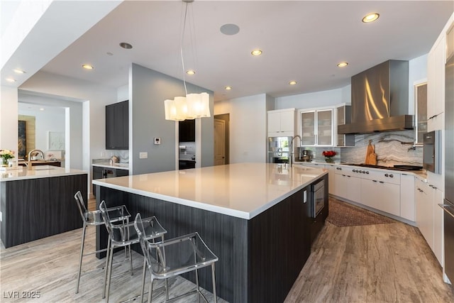 3458 W Agate Ave, Las Vegas, NV 89139 - kitchen featuring ventilation hood, a large island with sink, light wood-style flooring, a sink, and recessed lighting