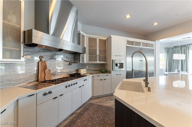 3458 W Agate Ave, Las Vegas, NV 89139 - kitchen with wall chimney range hood, a sink, light countertops, tasteful backsplash, and white cabinets